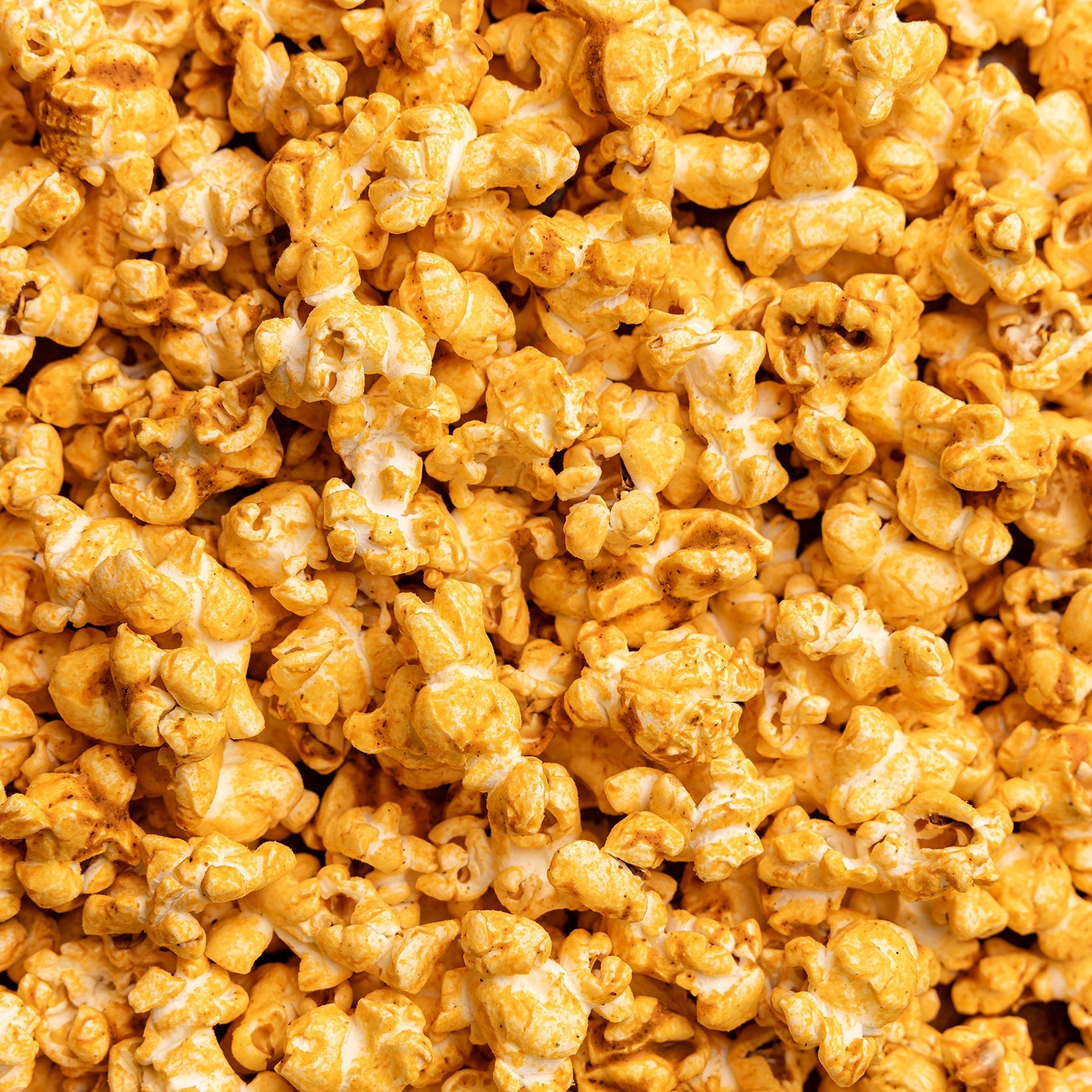 Close-up of a pile of poppy pimento cheese popcorn. Available at Be Charmed. 