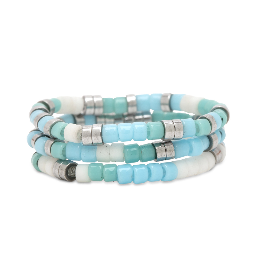 A three-ring stretch Pura Vida ring with seafoam green and white beads on a silver band. Available at Be Charmed