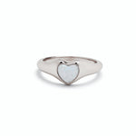 A silver-colored Pura VIda signet ring with a heart-shaped white opal stone set in the center. Available at Be Charmed