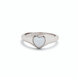 A silver-colored Pura VIda signet ring with a heart-shaped white opal stone set in the center. Available at Be Charmed