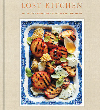 Book cover of 'The Lost Kitchen' with a dish of grilled peaches and honey on a beige background. Available at Be Charmed.  