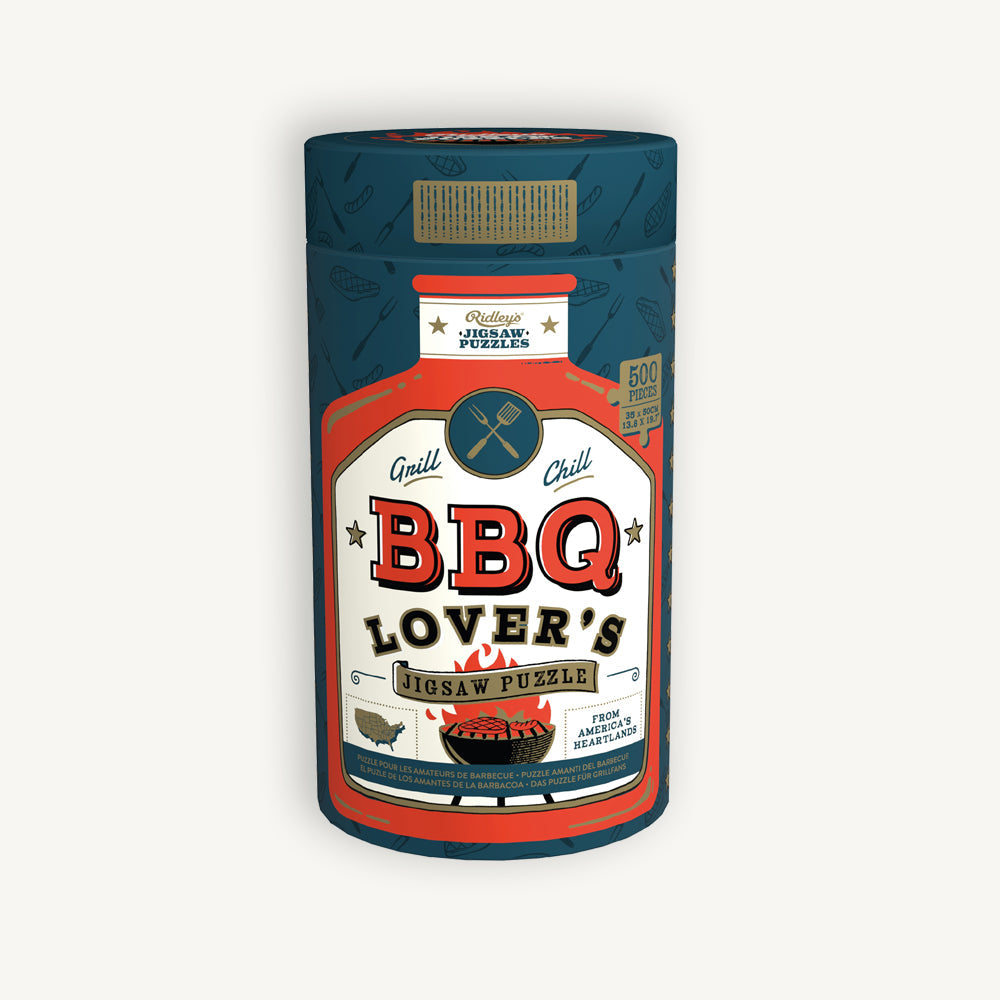 Colorful 500‑piece BBQ Lover’s jigsaw puzzle featuring grilling tools and regional BBQ styles—Available at Be Charmed
