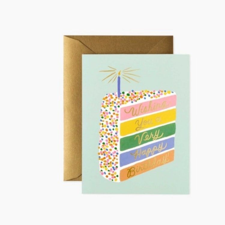 Greeting card with a colorful cake illustration and text, featuring a brown envelope on a white background. Available  at Be Charmed