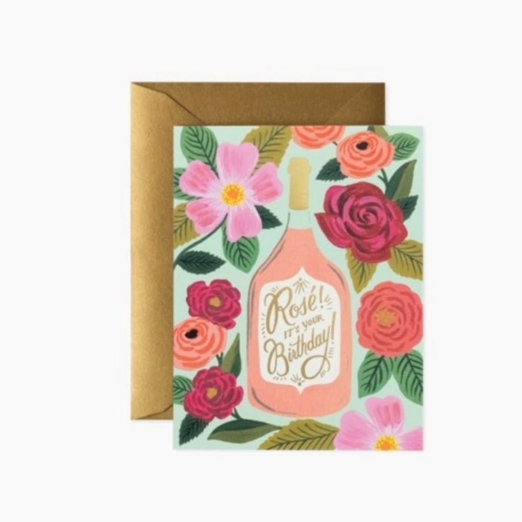 Greeting card with a bottle of rosé and floral design on a white background. Available at Be Charmed