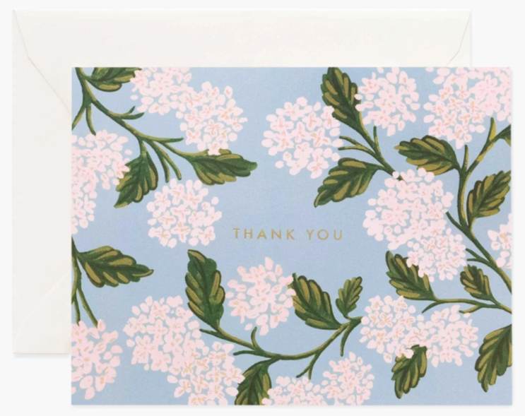 A folded thank you card with a floral pattern of hydrangeas on a blue background, with the words 'Thank You' printed on the front. Available at Be Charmed