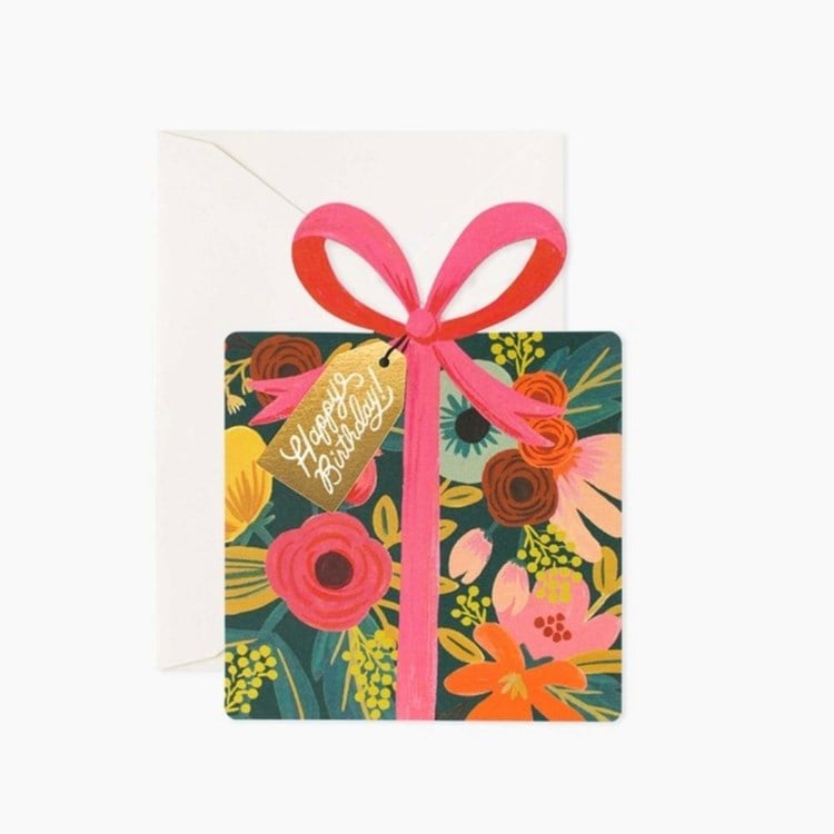 Floral card with a pink ribbon and 'Happy Birthday' tag on a white background. Available at Be Charmed