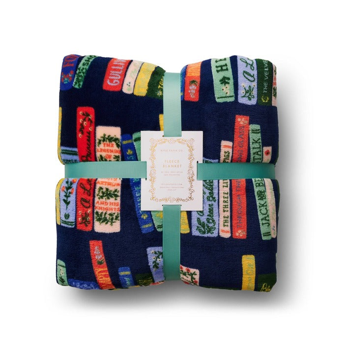 Folded blanket with colorful text pattern on a white background. Available at Be Charmed