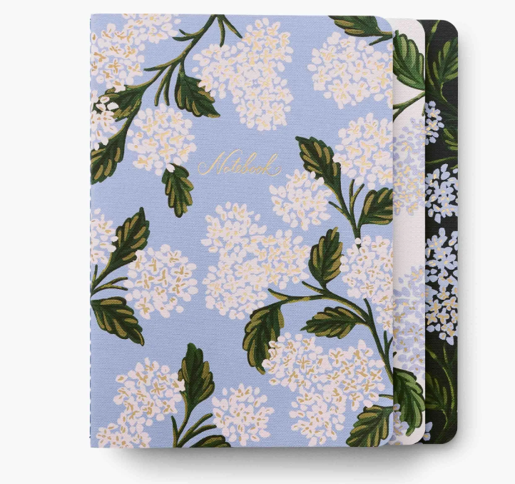 A set of three Hydrangea Rifle Paper Co. stitched notebooks with vibrant floral illustrations, available at Be Charmed.