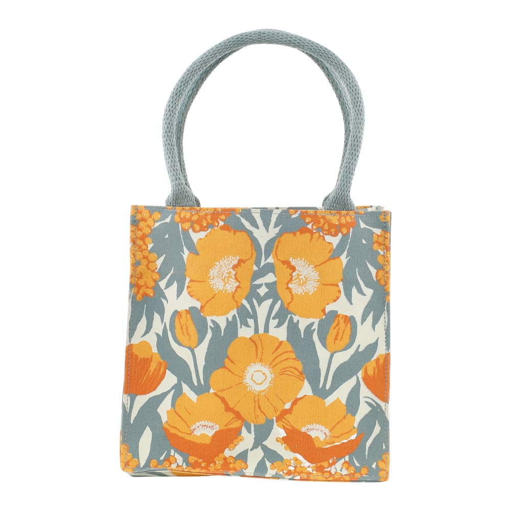 A square canvas tote bag featuring a retro floral pattern with orange poppies and blue-gray leaves on a cream background, complete with two thick braided blue-gray shoulder straps. Available at Be Charmed