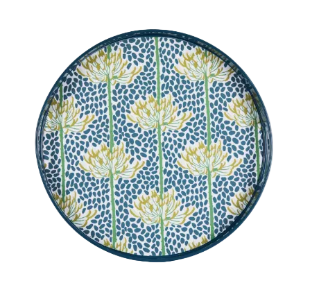 A round decorative tray with a dark blue rim, featuring a pattern of yellow and white flowers with green stems on a blue speckled background. Available at Be Charmed