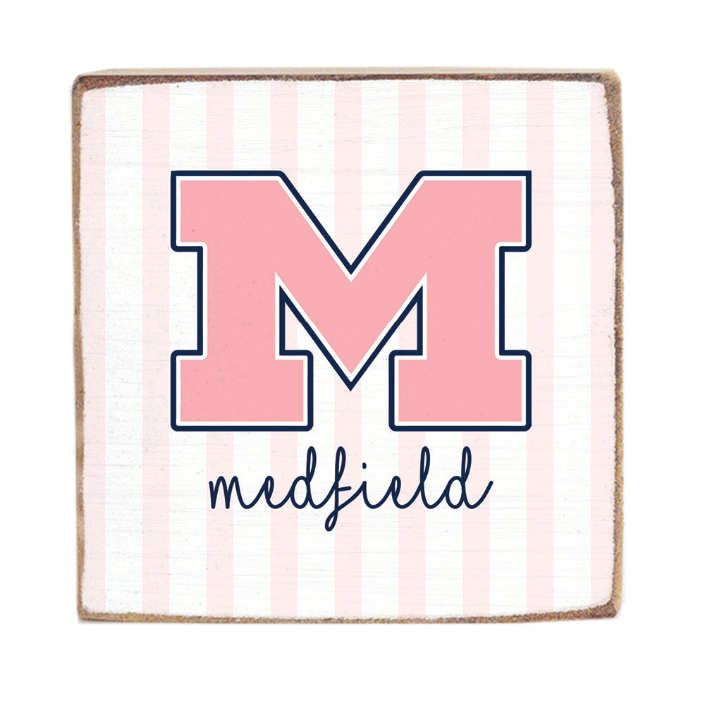 Wooden Block with a large pink 'M' and the word 'Medfield' on a striped background. Available at Be Charmed