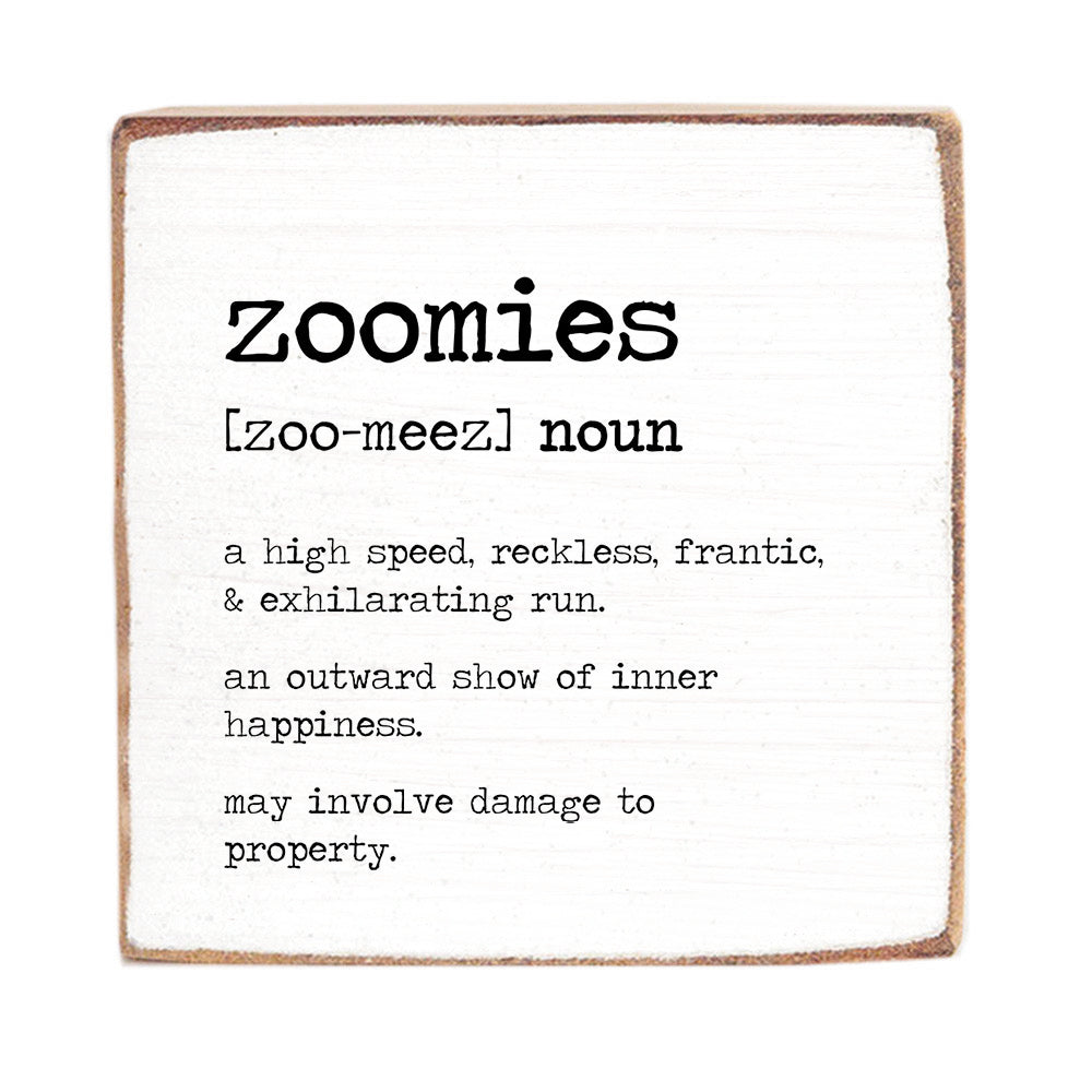 A 6 x 6 wooden block with a definition of 'zoomies' printed on it, placed against a white background. Available at Be Charmed