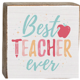 A decorative wooden block with 'Best Teacher Ever' printed on it, featuring multicolored text and a red apple symbol. Available at Be Charmed
