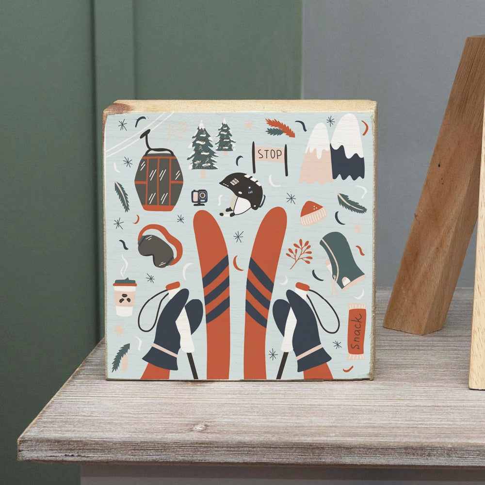 A decorative wooden block with a winter scene that includes chairlift, mountains, and ski trails. Available at Be Charmed