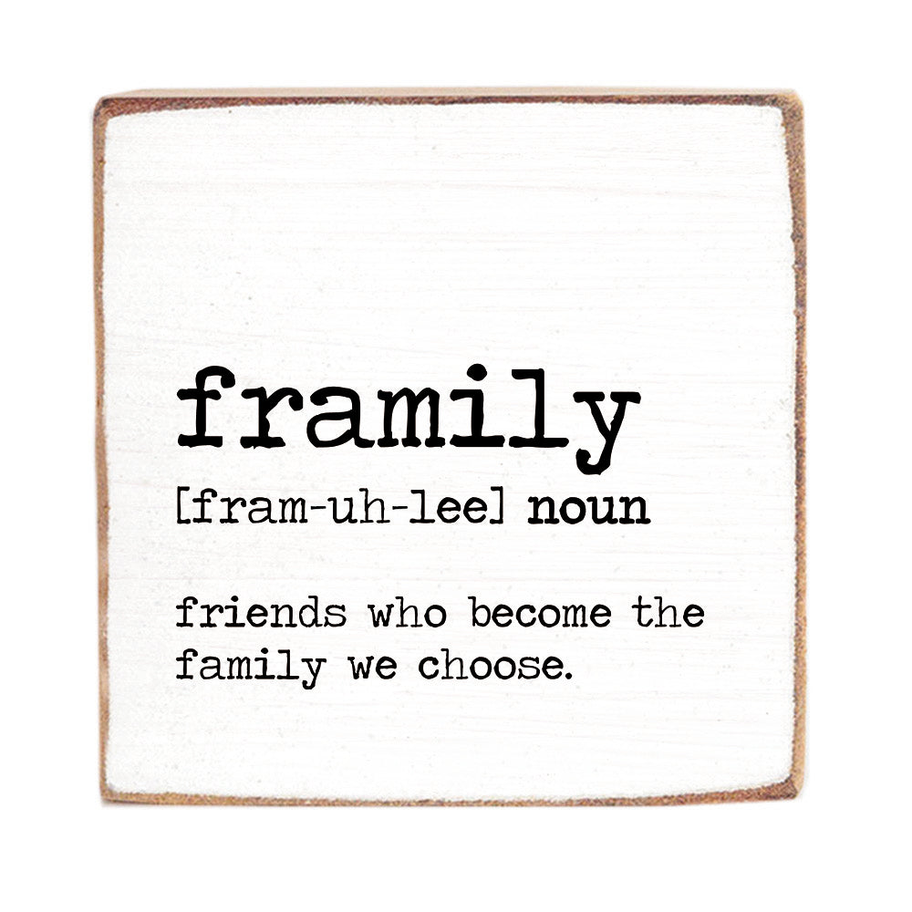 A decorative wooden block with the definition of 'framily' printed on it, indicating it's a noun and friends who become the family we choose. Available at Be Charmed