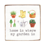 Decorative wood block with gardening-themed illustrations and text 'home is where my garden is' on a white background. Available at Be Charmed