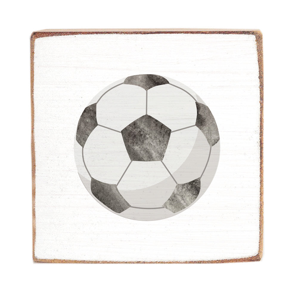 Soccer ball design on a square rustic wood block with a white background. Available at Be Charmed