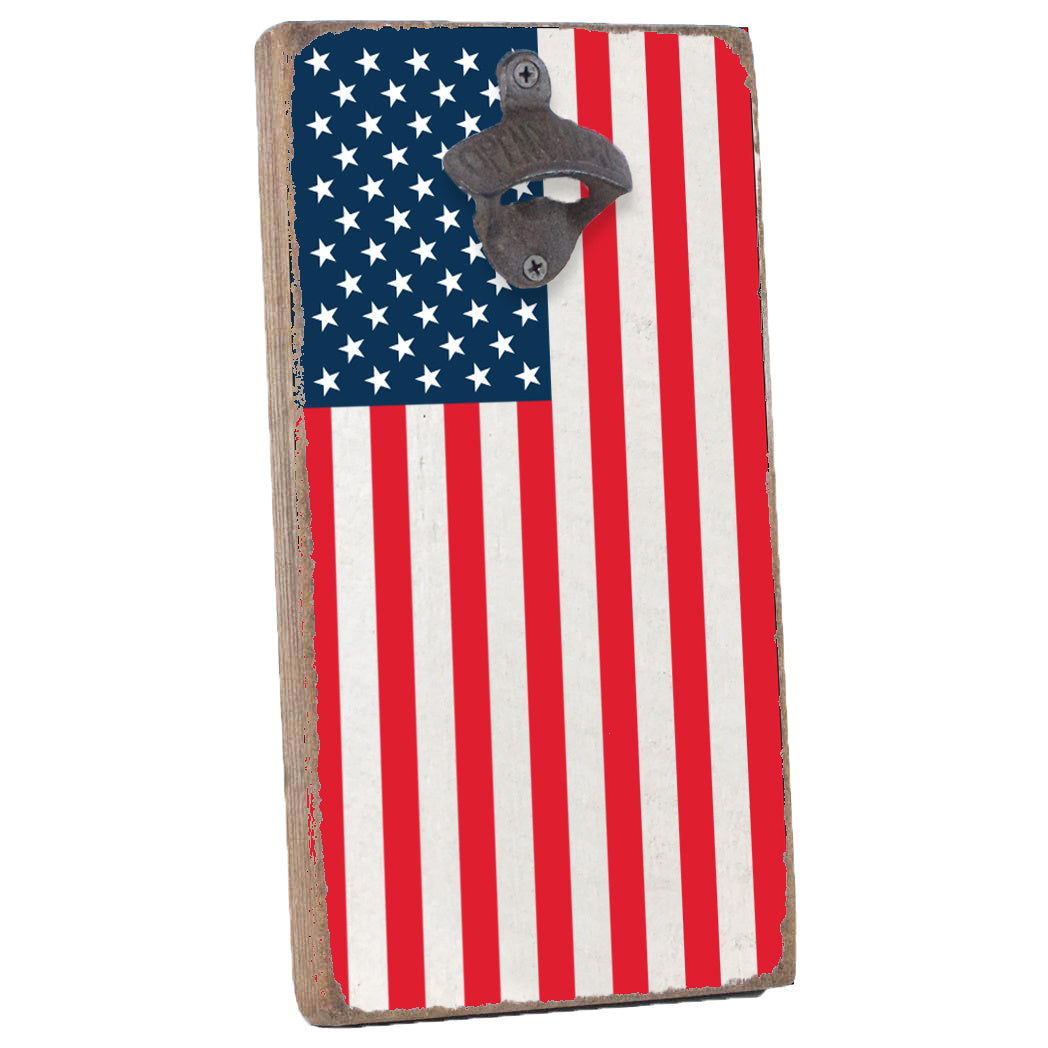 A wall-mounted bottle opener with an American flag design, featuring a star pattern on a blue background and a stripe pattern in red and white. Available at Be Charmed