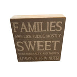 A rustic marlin decorative wooden block with the text 'FAMILIES ARE LIKE FUDGE, MOSTLY SWEET SOMETIMES SALTY, AND THERE'S ALWAYS A FEW NUTS!' printed on it. Available at Be Charmed