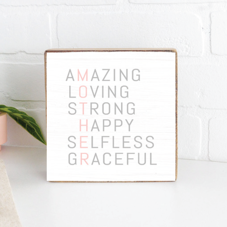 A Rustic Marlin wooden decorative block with the words 'AMAZING MOTHER STRONG HAPPY SELFLESS GRACEFUL' arranged in a stair-step pattern, painted in various colors. Available at Be Charmed