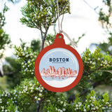 A round, red, white, and blue ornament with 'Boston, Massachusetts' written on it, hanging from a branch with green foliage in the background. Available at Be Charmed