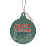 Decorative ornament with 'Sweet Caroline' text and cityscape design on a green background. Available at Be Charmed