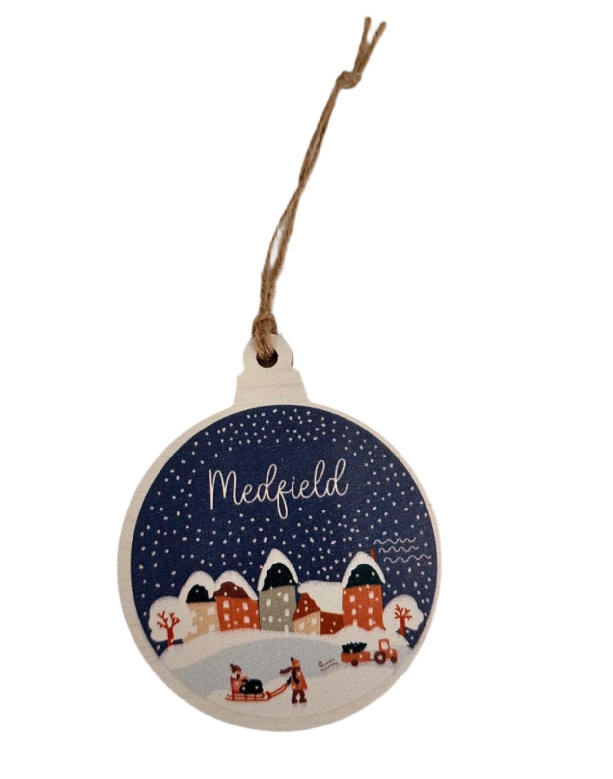 A round, rustic wooden ornament with a bulb design, featuring a vintage snow globe village scene in blue and white colors, with the word 'MEDField' written on it. Available at Be Charmed