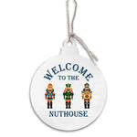 Round white ornament with nutcrackers and 'Welcome to the Nuthouse' text on a white background. Available at Be Charmed