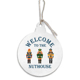 Round white ornament with nutcrackers and 'Welcome to the Nuthouse' text on a white background. Available at Be Charmed