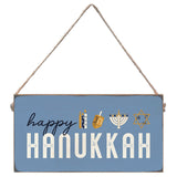 Hanging sign with 'Happy Hanukkah' text and symbols on a blue background. Available at Be Charmed