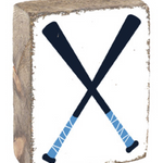 A rustic wooden block with a baseball bat design, featuring a blue and white bat on a square surface with a textured rustic background. Available at Be Charmed