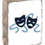 A rectangular wooden block with a rustic finish, featuring a blue theatrical mask design and the word 'DRAMA' on a wooden surface. Available at Be Charmed