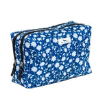 Blue floral patterned toiletry bag with a visible brand label on a white background. Available at Be Charmed