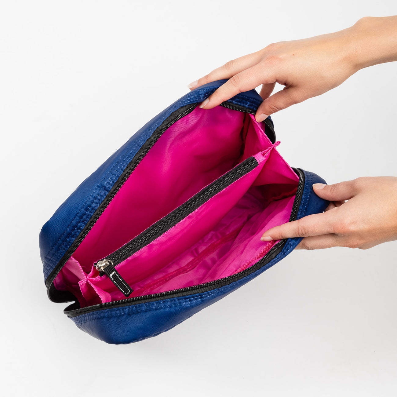 Inside of Navy Puffer Scout All Inclusive Travel Organizer – lightweight quilted toiletry bag with multiple compartments and zipper closures. Folds flat for easy packing. Available at Be Charmed.