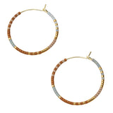 Pair of beaded hoop earrings with gold accents on a beige background. Available at Be Charmed