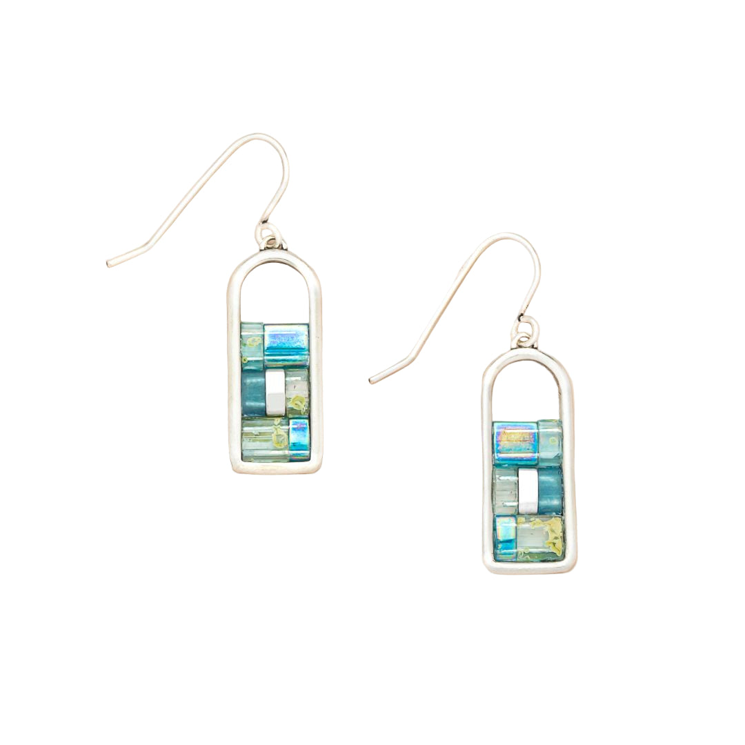 Pair of earrings with rectangular multicolored design on a beige background. Available at Be Charmed.