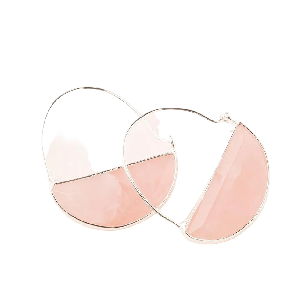 Heart-shaped earrings with pink and clear half-circle design on a light pink background. Available at Be charmed