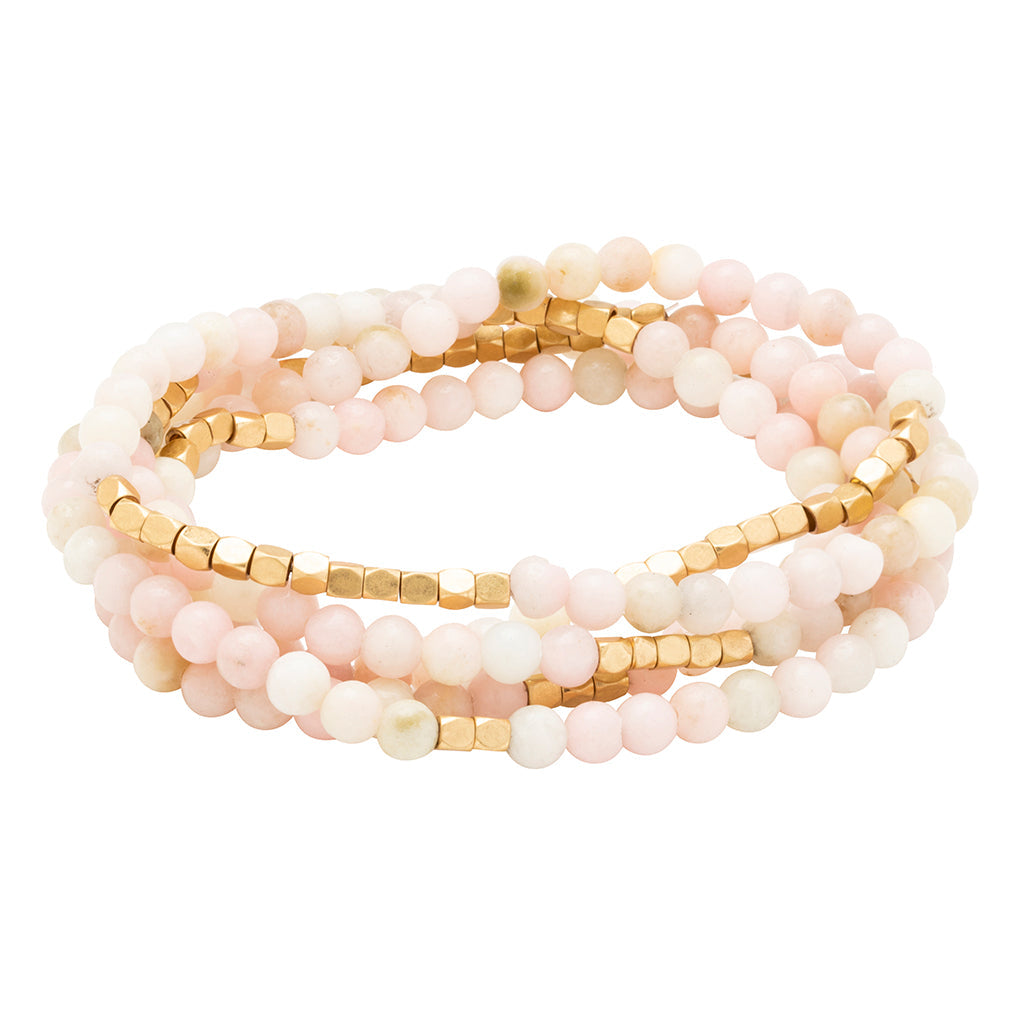 Stack of pink beaded bracelets with gold accents on a white background. Available at Be Charmed