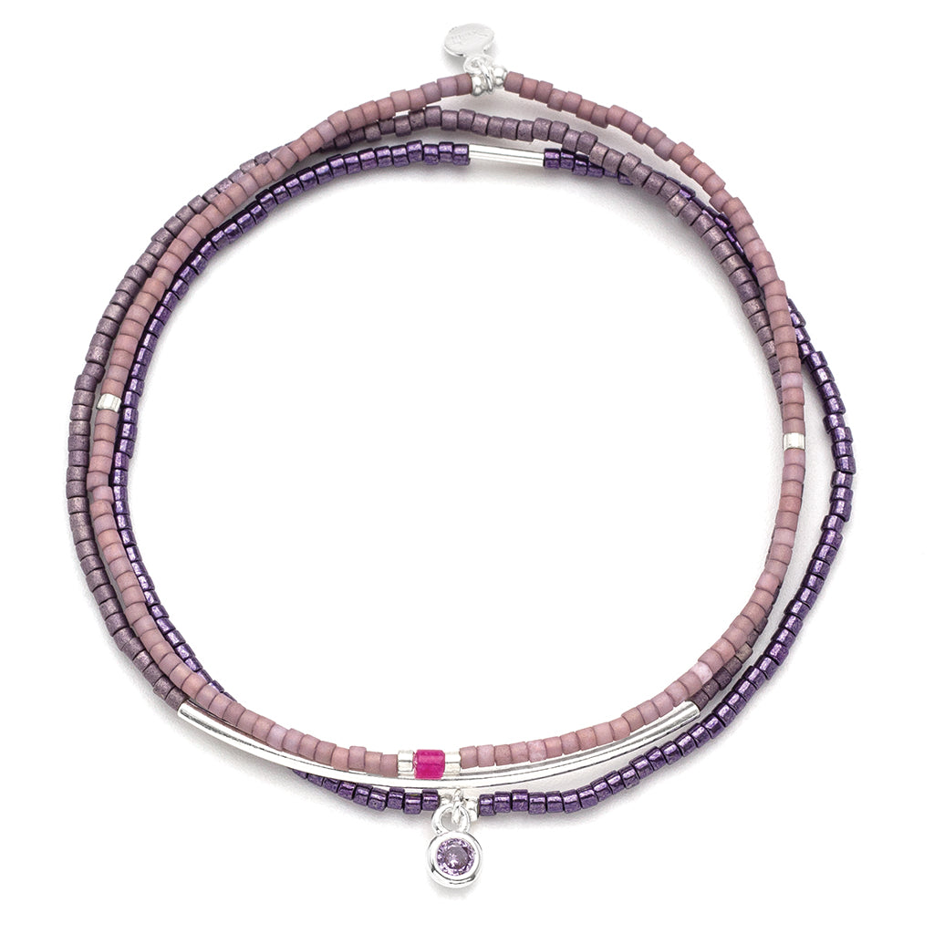 Purple beaded bracelet with silver accents on a white background. Available at Be Charmed