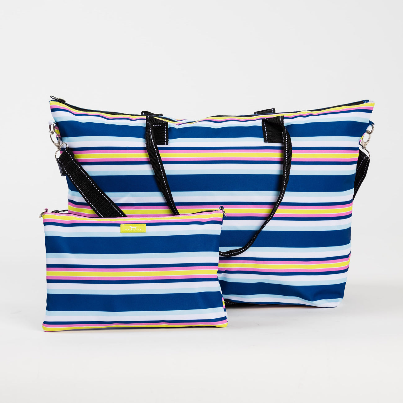 Fall in Line SCOUT Overpacker Large Foldable Travel Bag – 22″W × 14.5″H × 7″D lightweight poly‑canvas tote with interior zipper pouch that converts to a pocket. Holds up to 50 lbs, includes trolley sleeve and removable shoulder strap. Available at Be Charmed