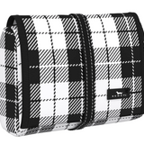 A rolled-up cosmetic or toiletry bag with a black and white checkered pattern, featuring a strap closure. Available at Be Charmed