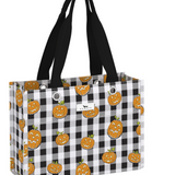 A tote bag with a black and white buffalo check pattern and an all-over print of orange jack-o'-lantern pumpkins. It features two black shoulder straps and a small white brand label on the front. Available at Be Charmed
