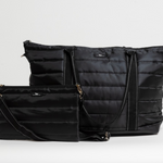 Black Puffer SCOUT Triple Advisor Travel Bag – quilted puffer 3‑in‑1 tote, removable pouch & crossbody strap. Trolley sleeve and lightweight design. Available at Be Charmed