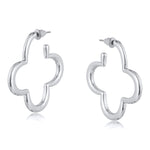 Silver Big Metal London Carmen earrings: 3.5 cm clover‑shaped floral metal hoops in radiant gold or sleek silver plating, hypoallergenic surgical steel posts, made with 50% recycled brass. Lightweight, sustainable fashion at its finest. Available at Be Charmed