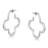 Silver Big Metal London Carmen earrings: 3.5 cm clover‑shaped floral metal hoops in radiant gold or sleek silver plating, hypoallergenic surgical steel posts, made with 50% recycled brass. Lightweight, sustainable fashion at its finest. Available at Be Charmed