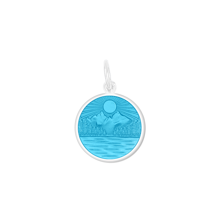 A Lola Light Blue sterling silver pendant with an enamel inlay featuring a lake and mountains scene, with the text 'LAKE LIFE IS THE BEST LIFE' on the back. Available at Be Charmed