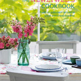 Cookbook cover titled 'The Newlywed's Cookbook' with a table setting and flowers. Available at Be Charmed