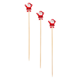 Three decorative sticks with Santa Claus figures on a white background. Available at Be Charmed