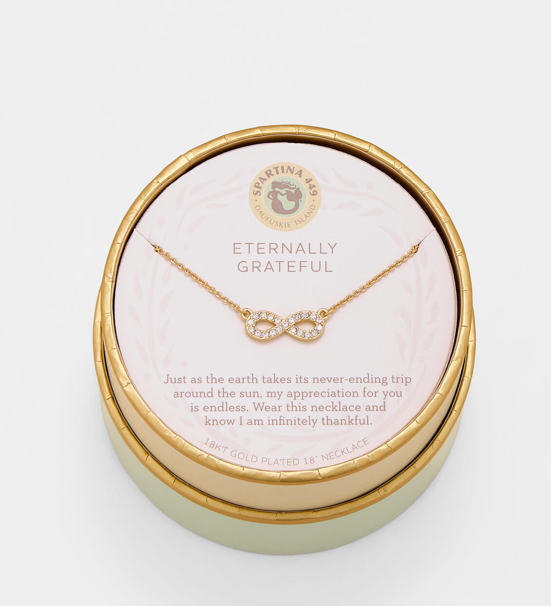 Gold necklace in a round jewelry box with a message on a white background. Available at Be Charmed