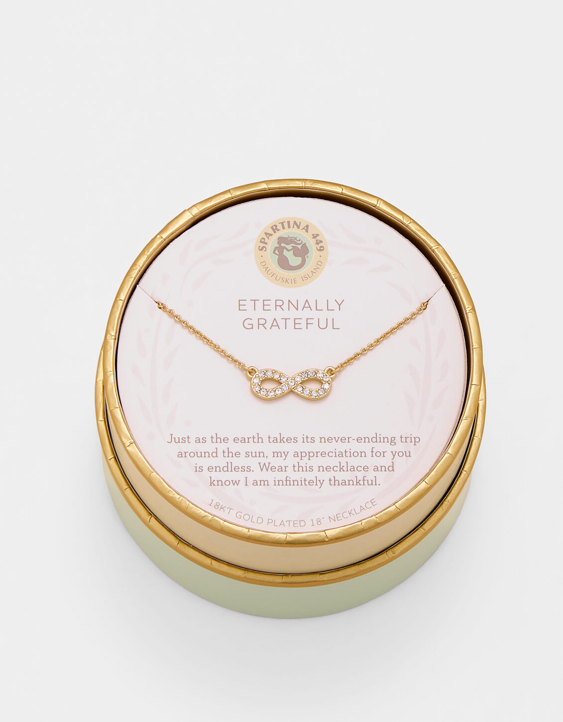 Gold necklace in a round jewelry box with a message on a white background. Available at Be Charmed